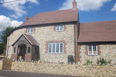 Medium Faced Flint Stone House with Large Faced Flint Stone Wall